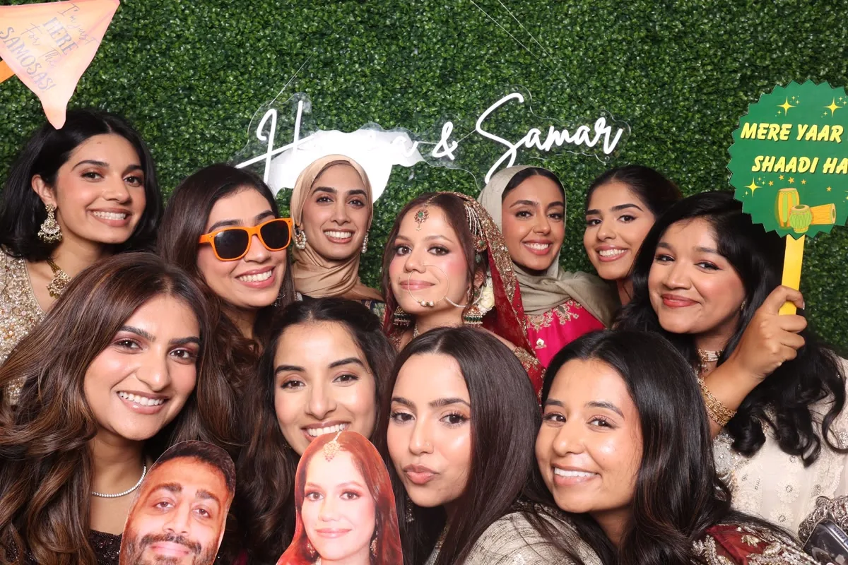 Clutch City luxury photo booth with boxwood greenery wall at Houston wedding